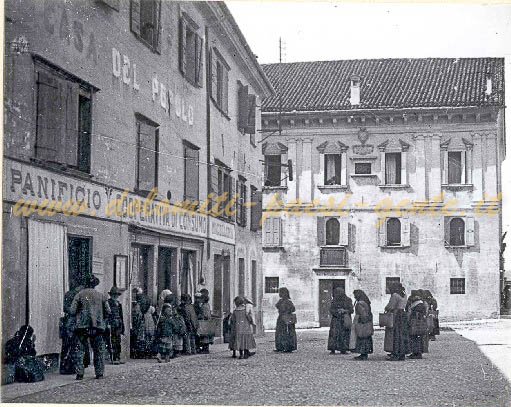 Mendicanti del venerdì in coda davanti alla coperativa di consumo in Piazza Duomo, Belluno 30 Aprile 1915. L'edificio è p~1